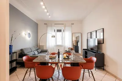 a living room with a table and chairs and a television at The Best Rent – Bright three-bedroom apartment along the Tiber River in Rome