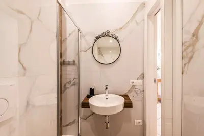 a white bathroom with a sink and a mirror at The Best Rent – Bright three-bedroom apartment along the Tiber River in Rome