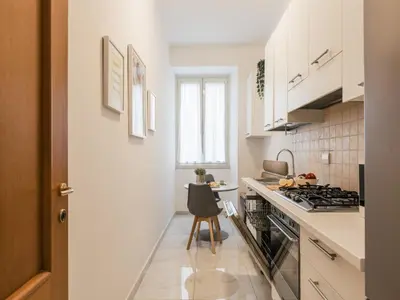 a kitchen with white cabinets and a stove top oven at The Best Rent – Bright two-bedrooms apartment in Testaccio area in Rome
