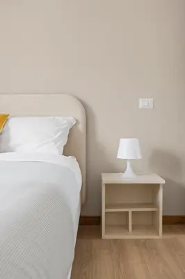 a white bed with a white lamp on a night stand at Sunny House Gianicolo in Rome