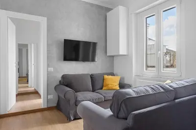 a living room with a couch and a tv on a wall at Sunny House Gianicolo in Rome