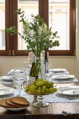 a table with a plate of grapes and a vase of flowers at RosaM Suite - Via Veneto 15 min walk from Spanish Steps Top Floor Luxury Apartment in Rome