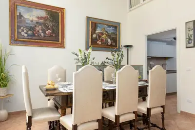 a dining room with a table with chairs and a painting at RosaM Suite - Via Veneto 15 min walk from Spanish Steps Top Floor Luxury Apartment in Rome
