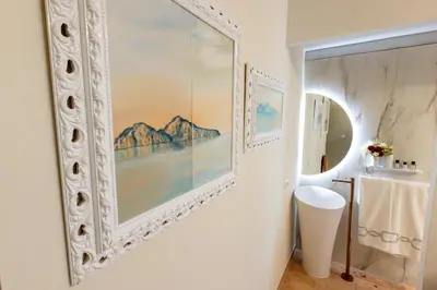 a bathroom with a large painting on the wall at RosaM Suite - Via Veneto 15 min walk from Spanish Steps Top Floor Luxury Apartment in Rome