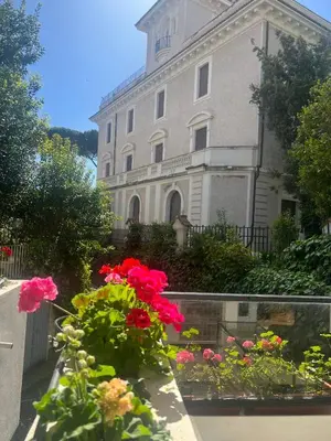 a building with a bunch of flowers in front of it at Villa Borghese Green Apartment in Rome