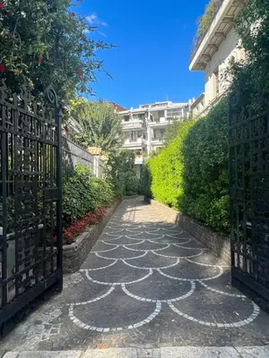 a gate to a garden with a stone pathway at Villa Borghese Green Apartment in Rome