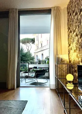 a living room with a sliding glass door to a balcony at Villa Borghese Green Apartment in Rome