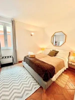 a bedroom with a bed with a mirror and a rug at Oasi di relax a Trastevere in Rome