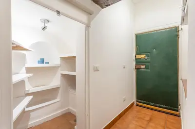 a green door in a room with white shelves at 2 BDR Navona Quintessential Charm in Rome