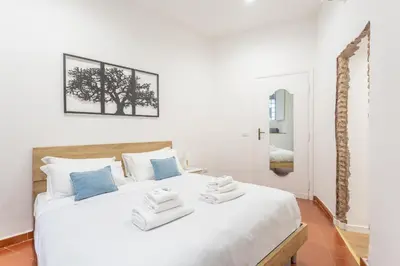 a bedroom with a white bed with towels on it at 2 BDR Navona Quintessential Charm in Rome