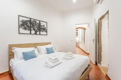 a bedroom with a large white bed with towels on it at 2 BDR Navona Quintessential Charm in Rome