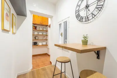 a kitchen with a table and a clock on the wall at 2 BDR Navona Quintessential Charm in Rome