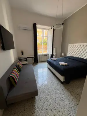 a bedroom with a bed and a couch and a window at Luxury room Anelli center of Roma in Rome