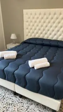 a blue bed with two white towels on it at Luxury room Anelli center of Roma in Rome