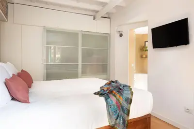 a bedroom with two beds and a flat screen tv at Idyllia - Cozy central retreat in Trastevere in Rome