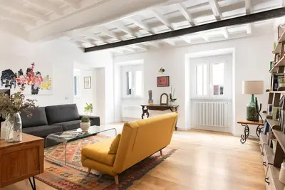 a living room with a yellow chair and a couch at Idyllia - Cozy central retreat in Trastevere in Rome