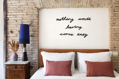 a bedroom with a bed with a sign on the wall at Idyllia - Cozy central retreat in Trastevere in Rome