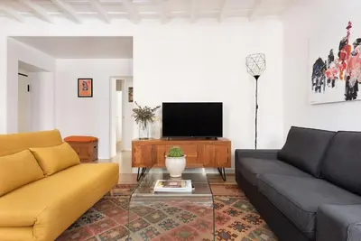 a living room with a couch and a tv at Idyllia - Cozy central retreat in Trastevere in Rome
