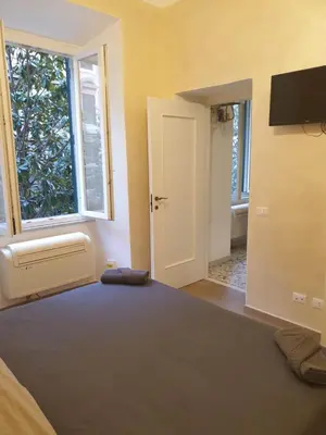 a room with a bed with a window and a television at Lombardo in Rome
