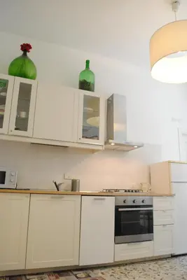 a kitchen with white cabinets and a stove top oven at Lombardo in Rome