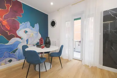 a dining room with a table and chairs and a painting at The blue Iris in Rome