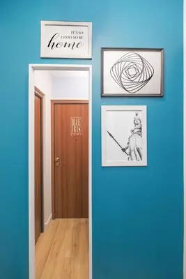 a hallway with three pictures on a blue wall at The blue Iris in Rome