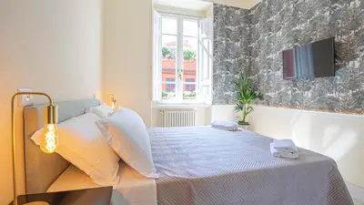 a bedroom with a bed with a tv on the wall at Sibylla in Rome in Rome