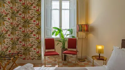a hotel room with two chairs and a window at Sibylla in Rome in Rome