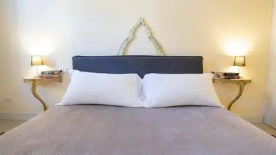 a bed with two white pillows and two lamps at Sibylla in Rome in Rome