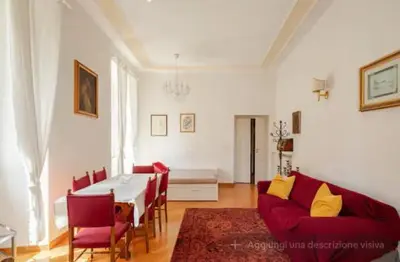 a living room with a table and a red couch at SAN PIETRO VATICAN AREA LARGE APARTMENT - near SUBWAY in Rome