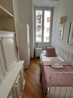 a small room with a bed and two windows at SAN PIETRO VATICAN AREA LARGE APARTMENT - near SUBWAY in Rome