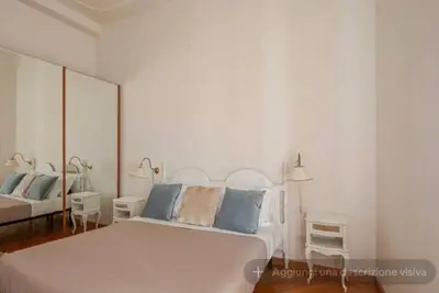 a white bedroom with a bed and two chairs at SAN PIETRO VATICAN AREA LARGE APARTMENT - near SUBWAY in Rome