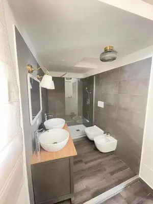 a bathroom with two sinks and a mirror at Lucilla’s Suite San Pietro station in Rome