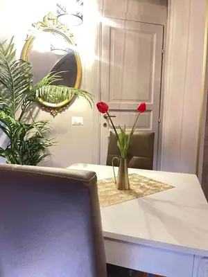 a table with a vase with red flowers on it at Lucilla’s Suite San Pietro station in Rome