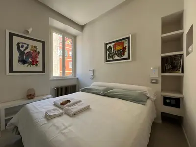 a bedroom with a white bed with towels on it at CARPE DIEM Ponte Milvio Olimpico Farnesina in Rome