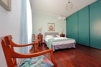 a hotel room with two beds and a chair at 4BNB - Leone IV Apartment in Rome