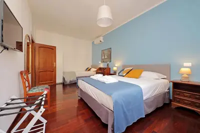 a hotel room with two beds and a television at 4BNB - Leone IV Apartment in Rome