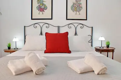 a bedroom with a white bed with a red pillow at 4BNB - Lungaretta Jacuzzi Apartment in Rome