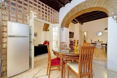 a kitchen and dining room with a table and a refrigerator at 4BNB - Lungaretta Jacuzzi Apartment in Rome