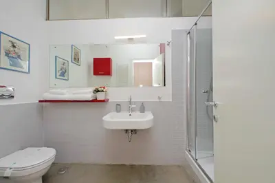a bathroom with a sink and a toilet and a red wall at 4BNB - Testaccio Apartment in Rome