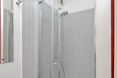 a bathroom with a white sink and a red door at 4BNB - Testaccio Apartment in Rome