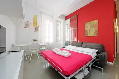 a living room with a couch and a red wall at 4BNB - Testaccio Apartment in Rome