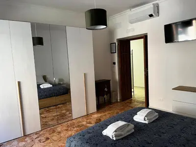 a bedroom with a mirror and a bed with two towels at Be Your Home - Stendardi's House in Rome