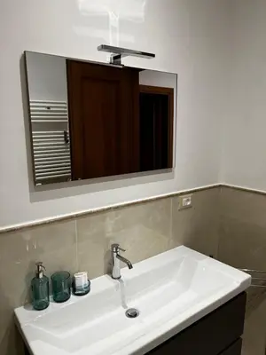 a bathroom sink with a large mirror above it at Be Your Home - Stendardi's House in Rome