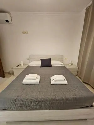 a bedroom with a large bed with two towels on it at Be Your Home - Stendardi's House in Rome