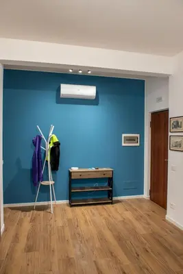 a room with a blue wall and a desk at Locazioni Ostiense - Domus William in Rome