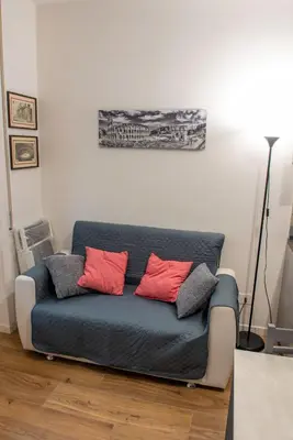 a blue couch with red pillows in a living room at Locazioni Ostiense - Domus William in Rome