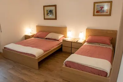 two beds in a small room with two lamps at Locazioni Ostiense - Domus William in Rome
