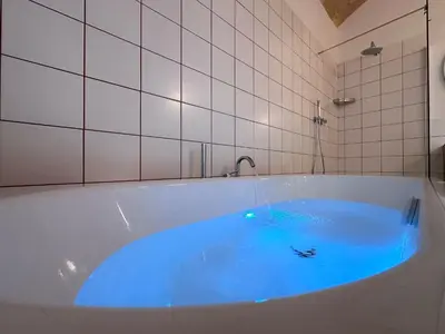 a bath tub with blue water in it at Santamaura Vatican Apartment in Rome