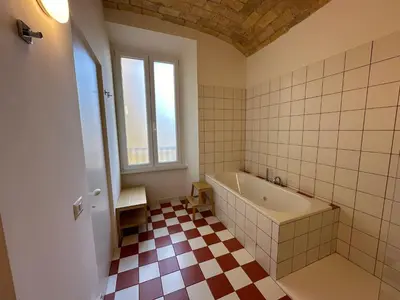 a bathroom with a tub and a checkered floor at Santamaura Vatican Apartment in Rome